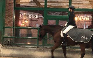 cavalière à cheval devant l'entrée de l'Etrier