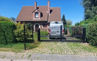 portail noir devant une maison unifamiliale