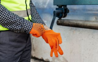 Ouvrier mettant des gants oranges