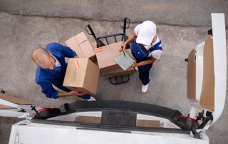 Deux professionnels qui chargent des caisses dans un camion