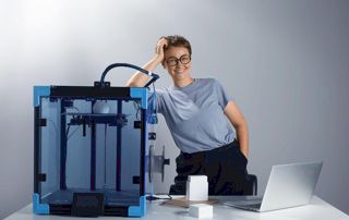 femme accoudée sur une machine 3D