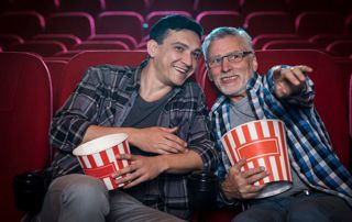 deux hommes au cinéma avec des pop corn