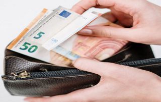 mains sortant des billets d'un portefeuille