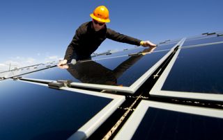 photo d'un homme plaçant un panneau solaire