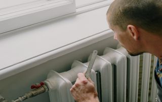 chauffagiste réparant un radiateur