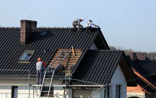 ouvriers couvreurs en train de travailler sur une toiture